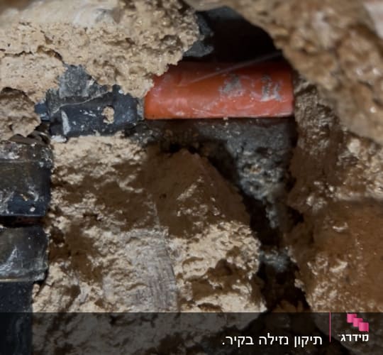 צינור מים בתוך קיר עם טיח שבור